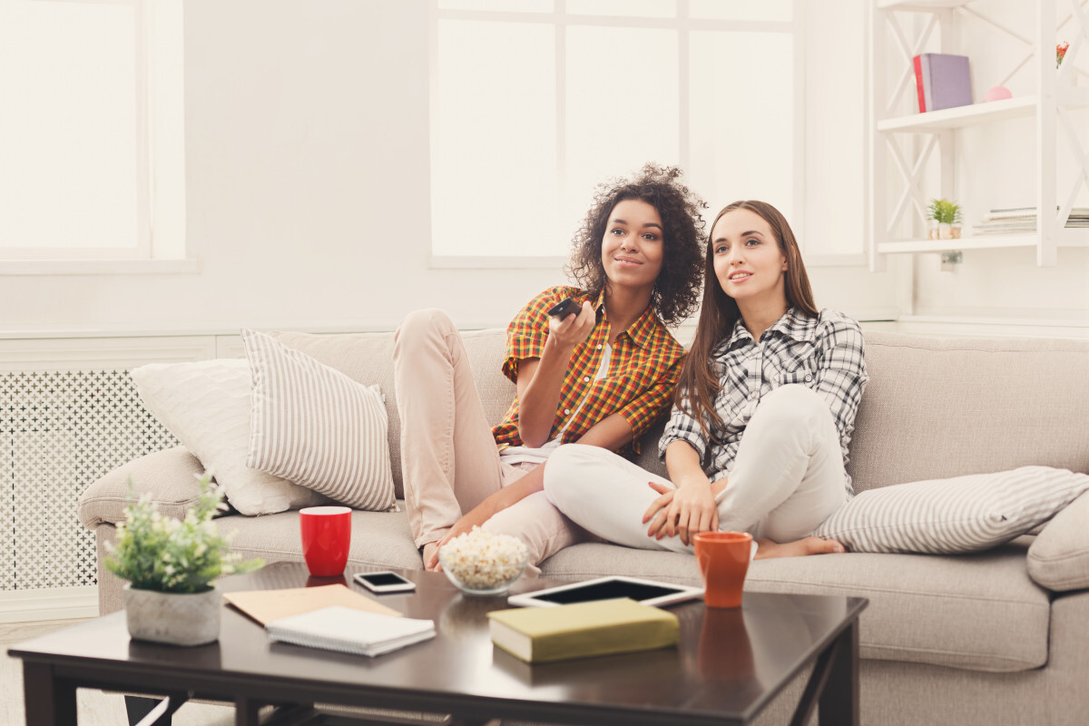 smiling-female-friends-watching-tv-at-home-2021-08-26-16-32-24-_p17394